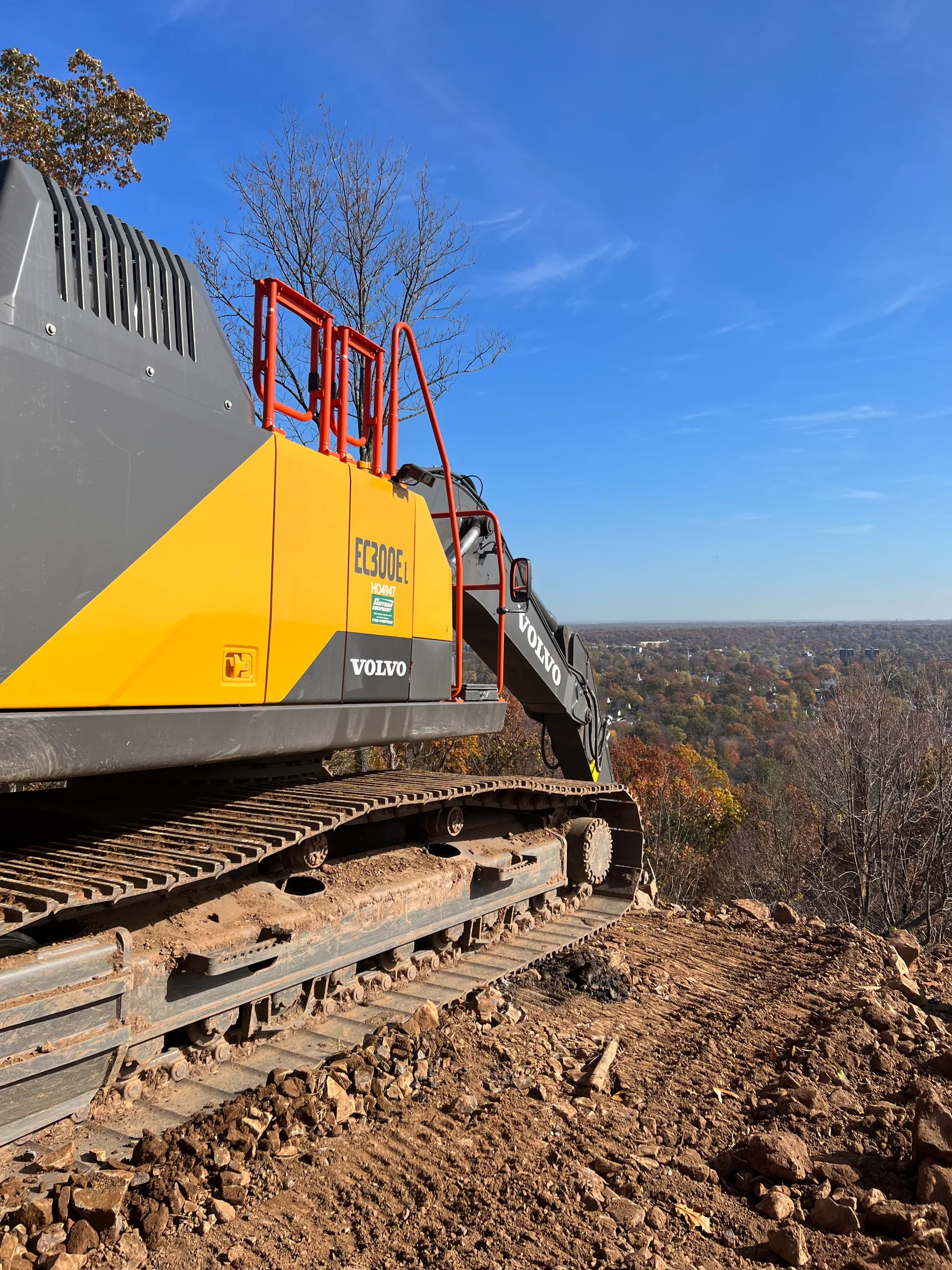 Excavator reaching over Hillside